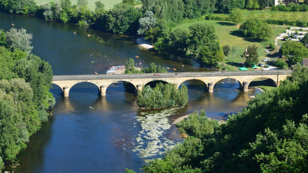 Beautiful aerial view of a stone bridge over the Dordogne River in summer.